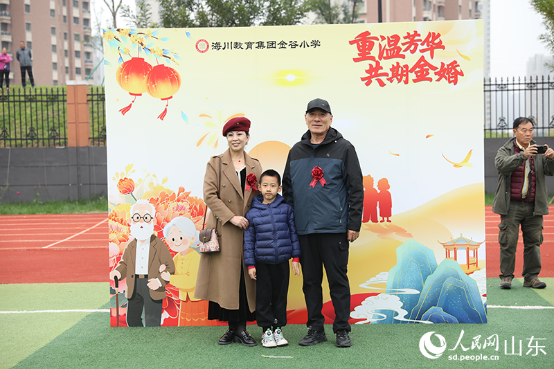 一对老人携孙子在现场打卡合影。他们历经岁月沉淀的灿烂笑容，与孩子的朝气相互映衬，生动诠释着幸福与传承。人民网记者 刘祺摄