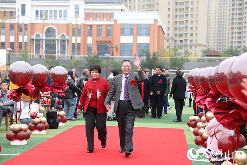 99对金婚老人在学生志愿者的引导与祝福下，携手踏上红毯，重现数十年前的美好瞬间。人民网记者 刘祺摄