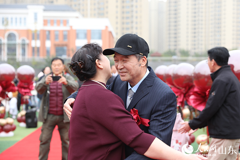 在济南市高新区金谷小学“重温芳华 共期金婚”活动现场，一对金婚老人深情相拥，重现数十年前的美好瞬间，定格了历久弥坚的幸福。人民网记者 刘祺摄