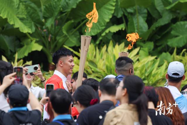 澳门站第四十八棒火炬手罗协铭在市民的欢呼中点燃火炬。