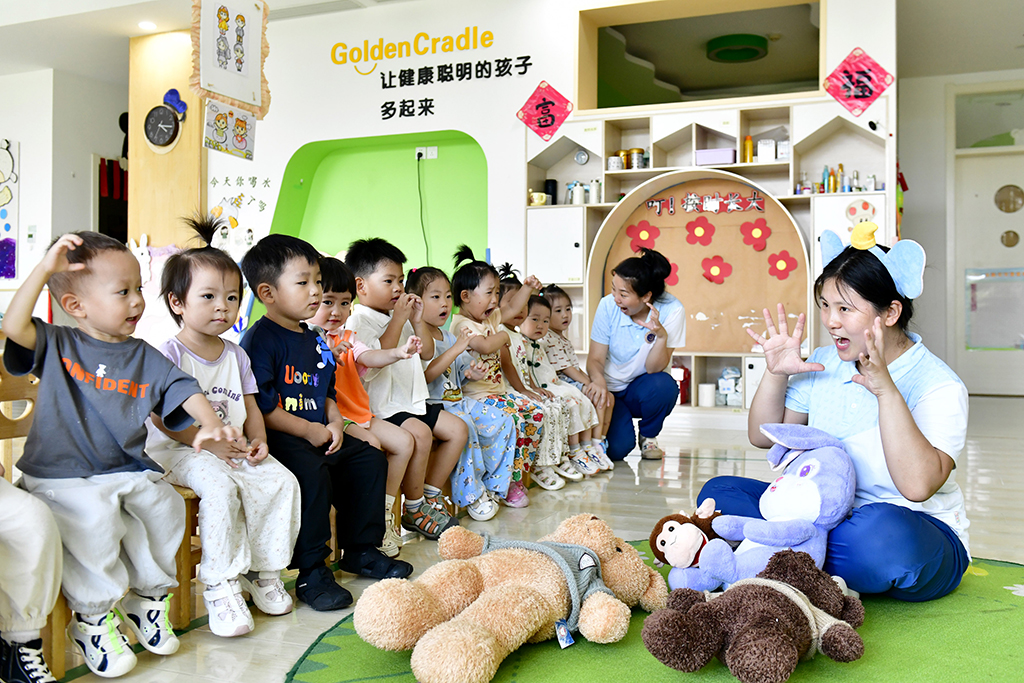 2025年7月22日，在山东省滨州市博兴县金色摇篮幼儿园，老师带托育班的孩子做游戏。新华社记者 郭绪雷 摄