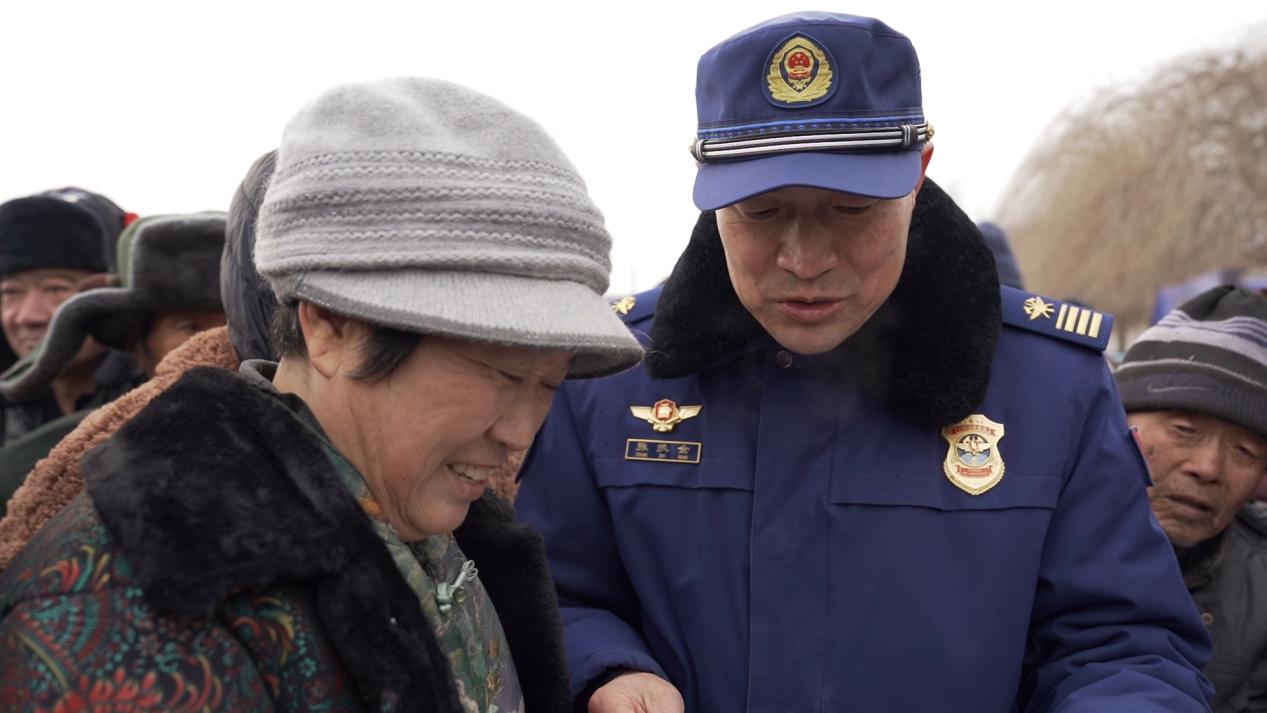 张执全在集市上讲解消防安全常识。凌海市消防救援局商业路消防救援站张文摄